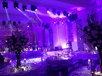 Wedding at the Landmark Hotel, London with stage, lighting and shimmer curtains with draping backdrop